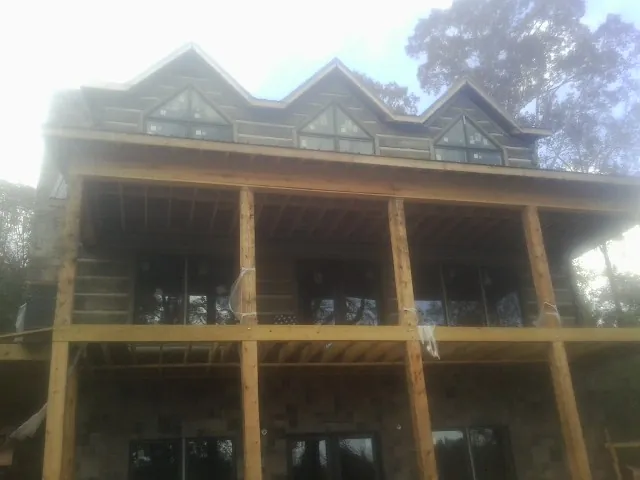 Dormers and porch framing on a large log home under construction — Roof Coating work by our crew in Rhoadesville
