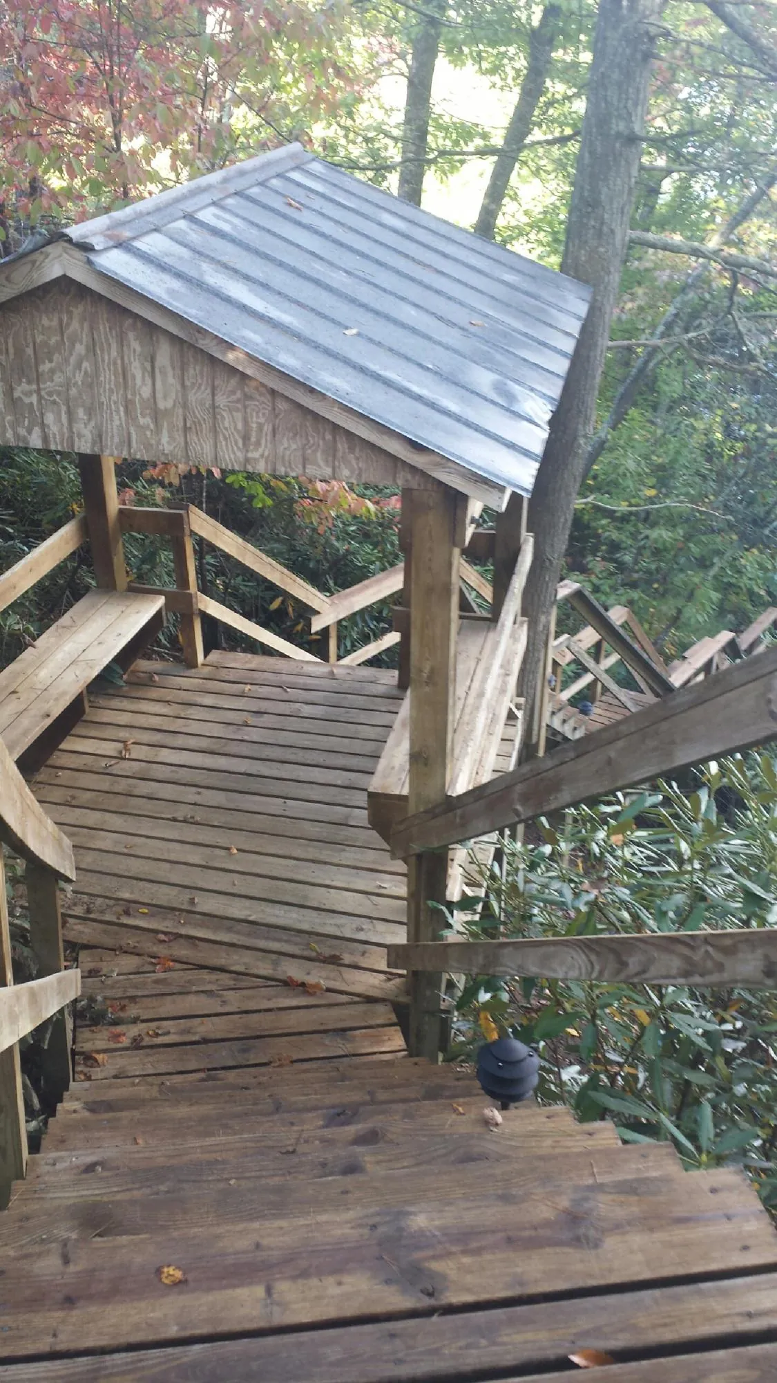Metal roofed shelter over wooden steps on a wooded walkway — Skylight Repair & Installation work by our crew in Rhoadesville